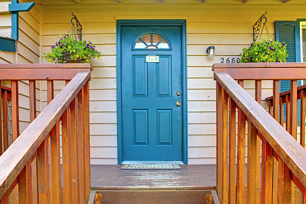Entrance porch with blue door and stairs with railings