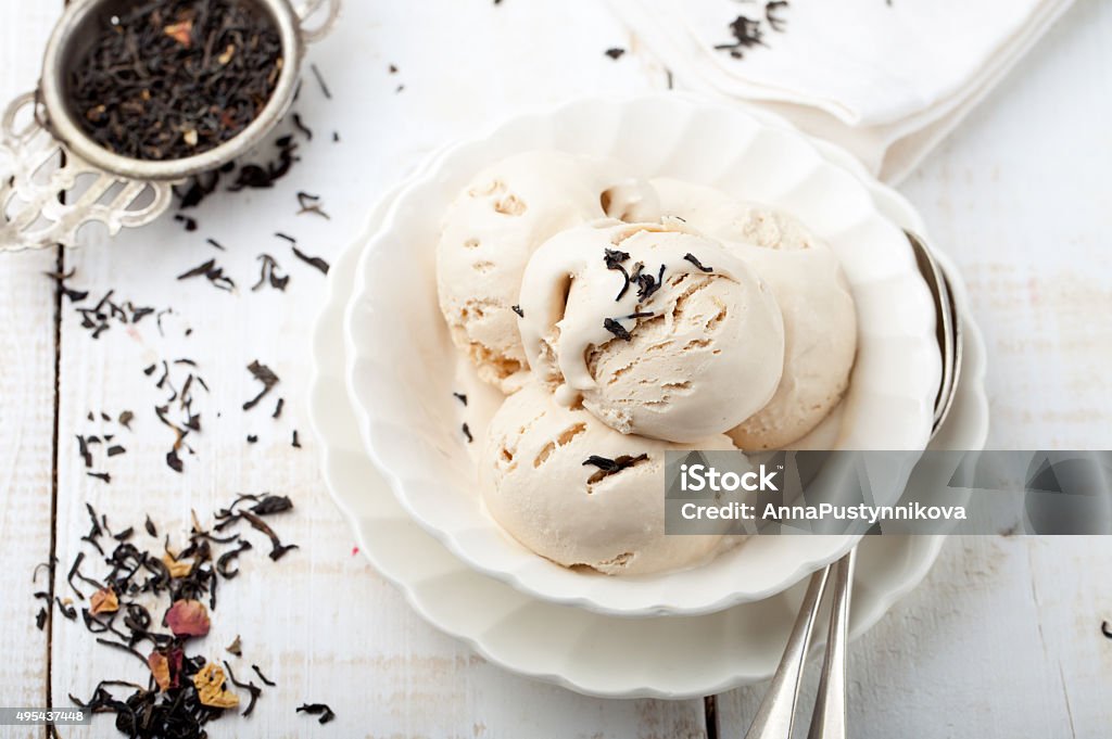 Ice cream with Earl grey tea flavor. White ceramic bowl Ice cream with Earl grey tea flavor in white ceramic bowl on a white wooden background Earl Stock Photo