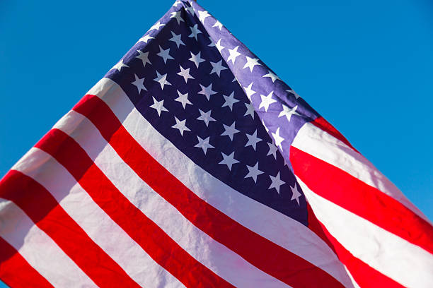 istock American flag over blue sky 495438336