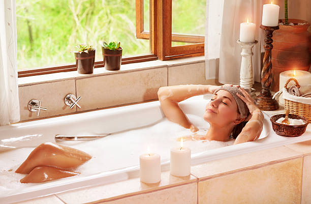 Woman relaxing at spa resort Woman relaxing at spa resort, lying down in the bath with closed eyes and make a compress, pleasure and healthy lifestyle girls bath stock pictures, royalty-free photos & images