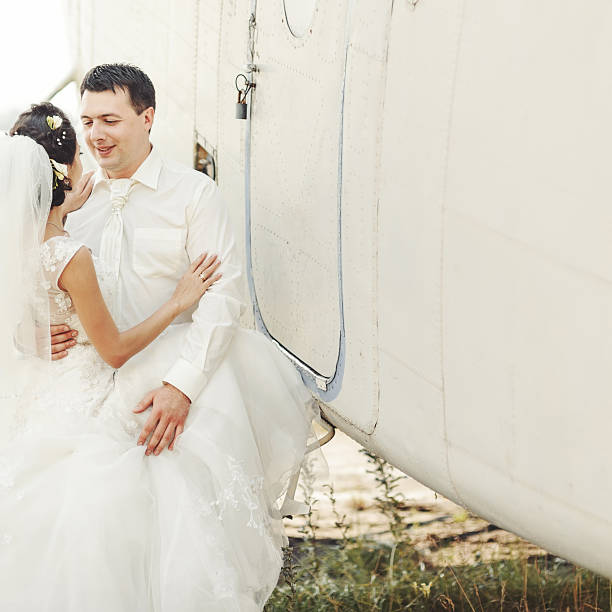 istock Wedding summer couple together posing against airplane. 495441022
