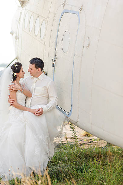 istock Wedding summer couple together posing against airplane. 495441076