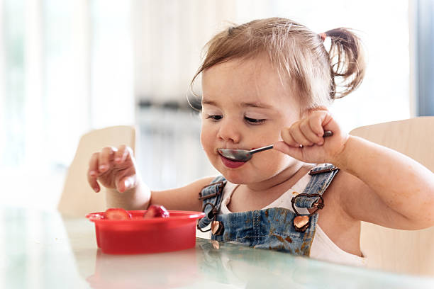 Little 2 years old girl eating jello stock photo