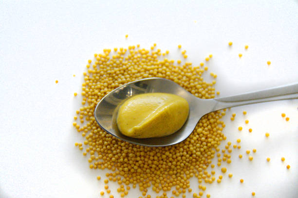 portion of mustard over the pile of yellow mustard seeds Small portion of mustard over the pile of yellow mustard seeds dijonnaise stock pictures, royalty-free photos & images