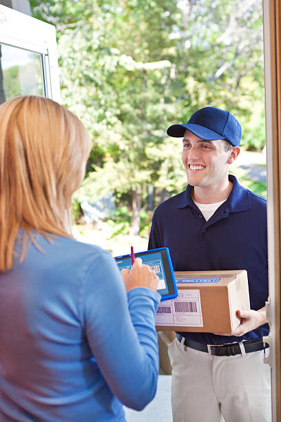 istock Delivery Person Delivering Package Box Container to Home Customer 495469880