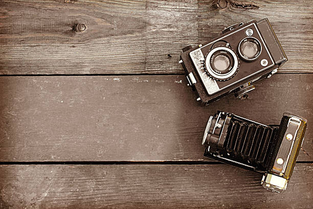 istock Old retro camera on vintage wooden background 495470647