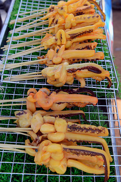 Squid on a grill at a folk festival in the province of Amnat Charoen northwest of Ubon Ratchathani in northeastern Thailand in South East Asia.