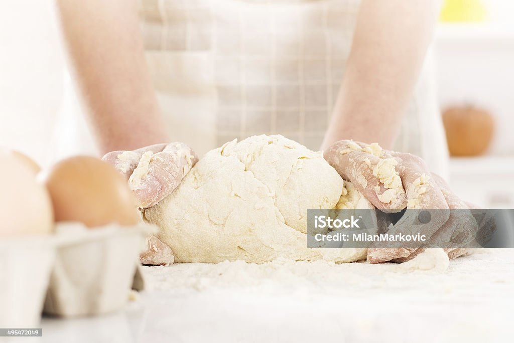 Making dough Pair of woman's hands kneading dough on table. Close-up. Adult Stock Photo