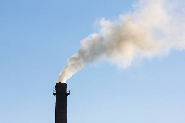 istock Smoking chimney and clear blue sky in background 495472106