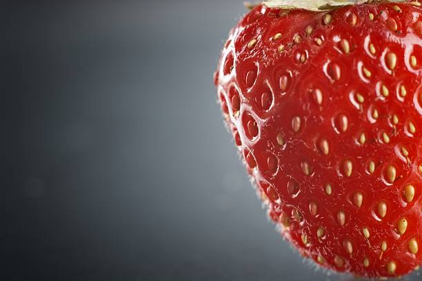 istock Crooped strawberry on natural dark background 495474220