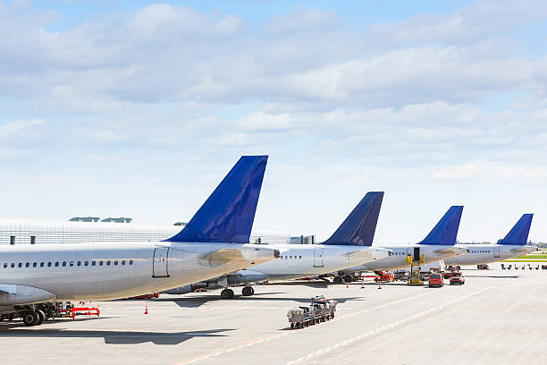 Tails of some airplanes at airport during boarding operation stock photo