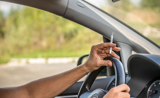 Man driving and smoking joint