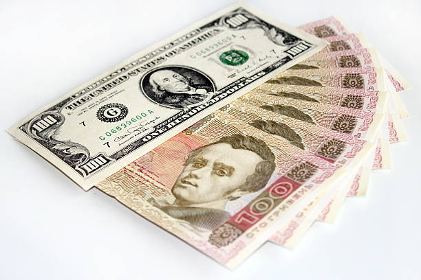 istock 100 dollars and grivnas banknotes isolated on dark background 495483558