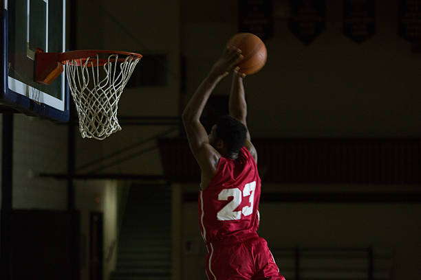 istock Young men dunking a basketball in a gymnasium 495490822