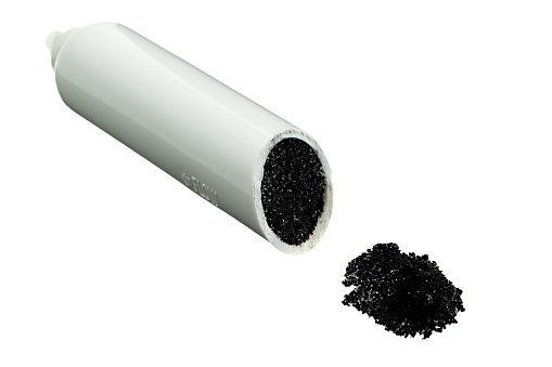 Activated carbon (charcoal or activated coal) water filter, sliced to show inside of the filter. Isolated on white background.