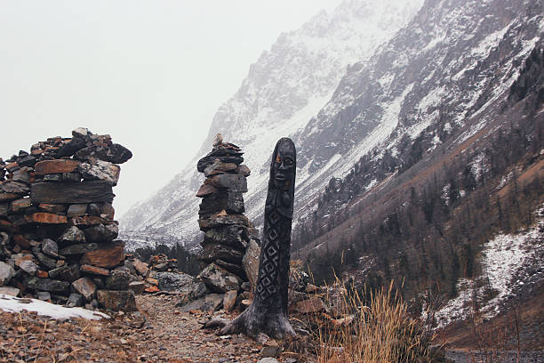 Winter mountain pass. Heathen pagan idol made from the wood. stock photo