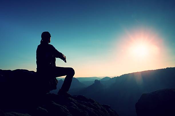 istock Young man in sportswear sit on cliff and looking bellow 495494810