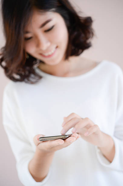 istock asia young beautiful lady touching and browsing her smart phone 495495298