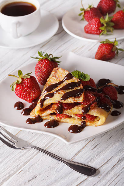 istock crepes with strawberries and coffee close-up. Vertical 495504366