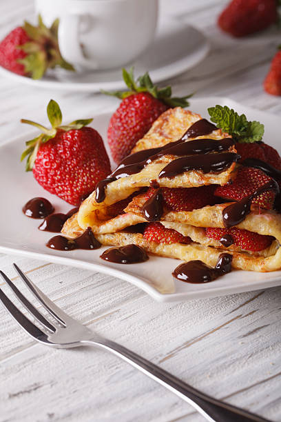 istock crepes with fresh strawberries and chocolate, vertical 495504634