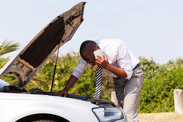 young man with broken down car calling for help young man with broken down car with bonnet open calling for help vehicle breakdown stock pictures, royalty-free photos & images