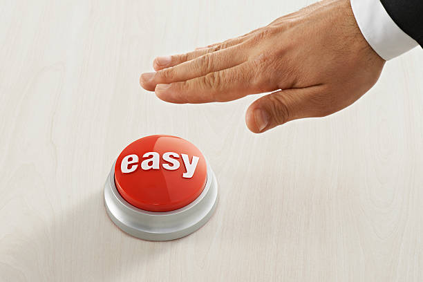 Businessman Reaching Easy Button Businessman reaching red easy button. effortless stock pictures, royalty-free photos & images