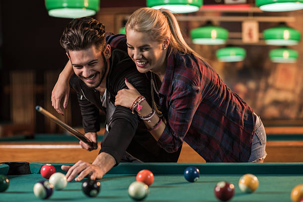 istock Cheerful embraced couple playing billiard in a pool hall. 495508736