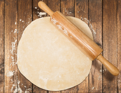 Rolled out dough on table with rolling pin