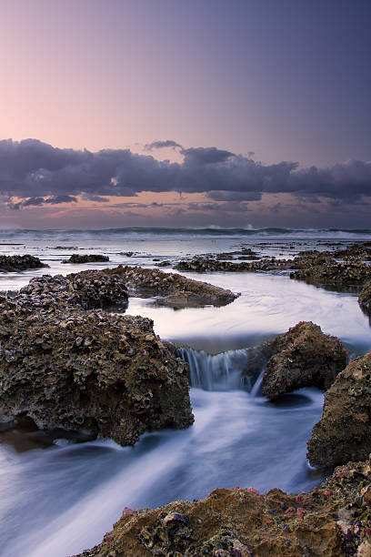 istock Sunrise landscape of ocean with waves clouds and rocks 495510559