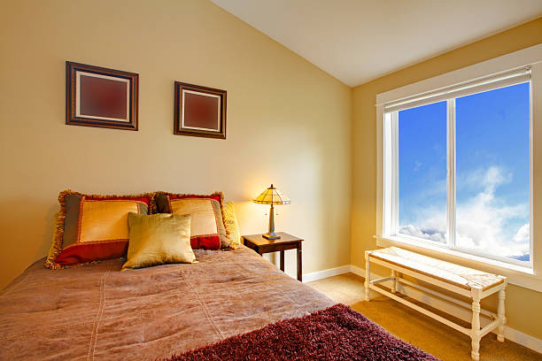 istock Brown bed with gold pillows and blue window 495511399