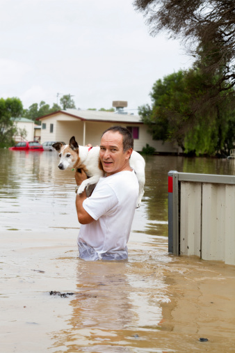 A man leaving his home walking through flood waters.