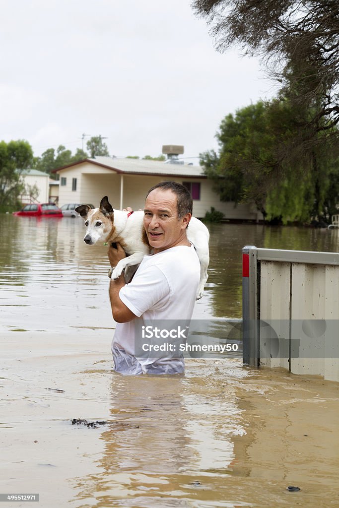 Flood Waters A man leaving his home walking through flood waters. Flood Stock Photo