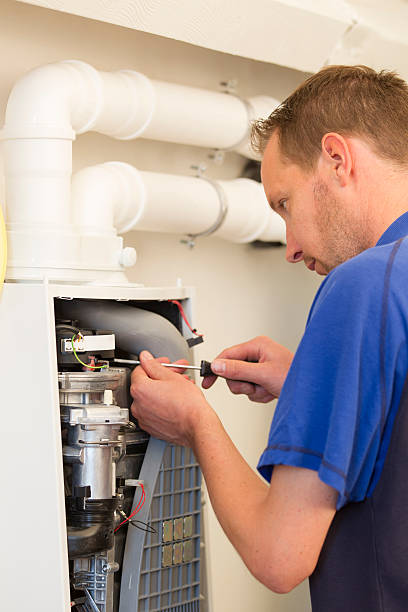 istock Plumber repairing a heater in house 495514491