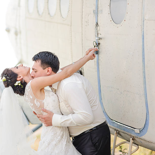 istock Wedding summer couple together posing against airplane. 495519050