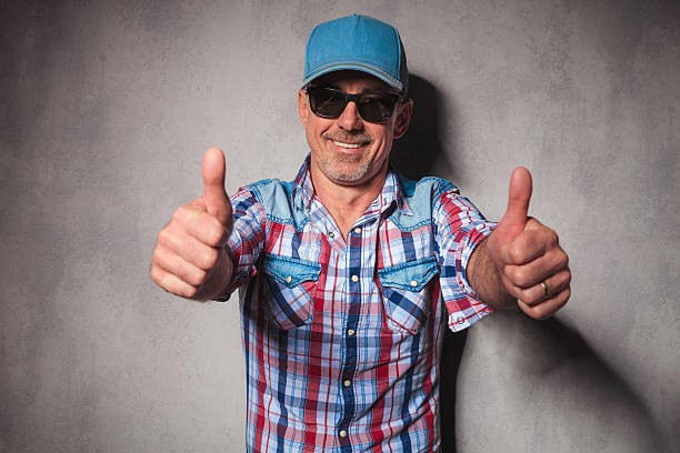 aged happy casual man making the ok thumbs up hand sign in studio