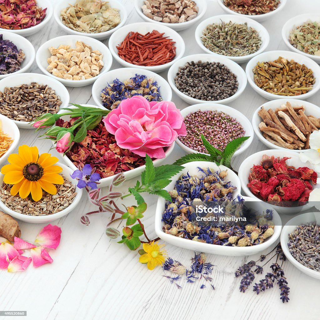 Natural Health Care Flower and herb selection used in herbal medicine in porcelain bowls over distressed wooden background. Selective focus. 2015 Stock Photo