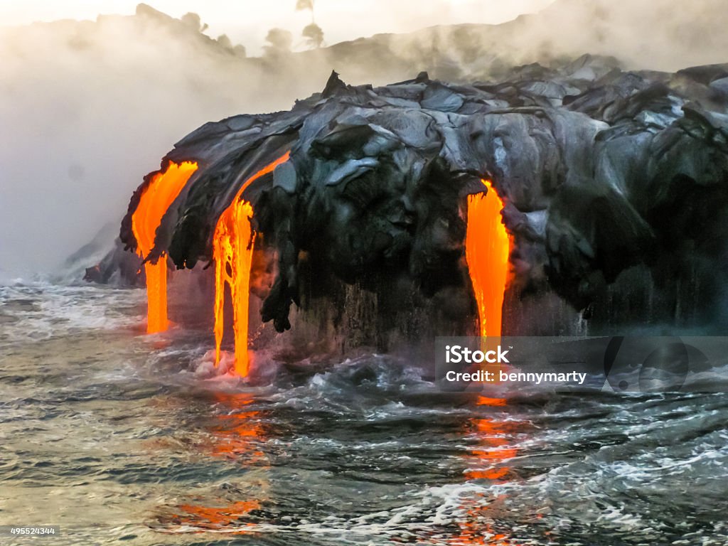 Volcano Sea view of Kilauea Volcano in Big Island, Hawaii, United States. A restless volcano that has been in business since 1983. Shot taken at sunset when the lava glows in the dark as jumps into the sea. Lava Stock Photo