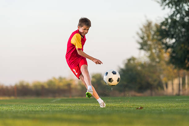 istock kid kicking a soccer ball 495534258