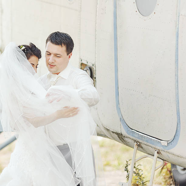 istock Wedding summer couple together posing against airplane. 495536392
