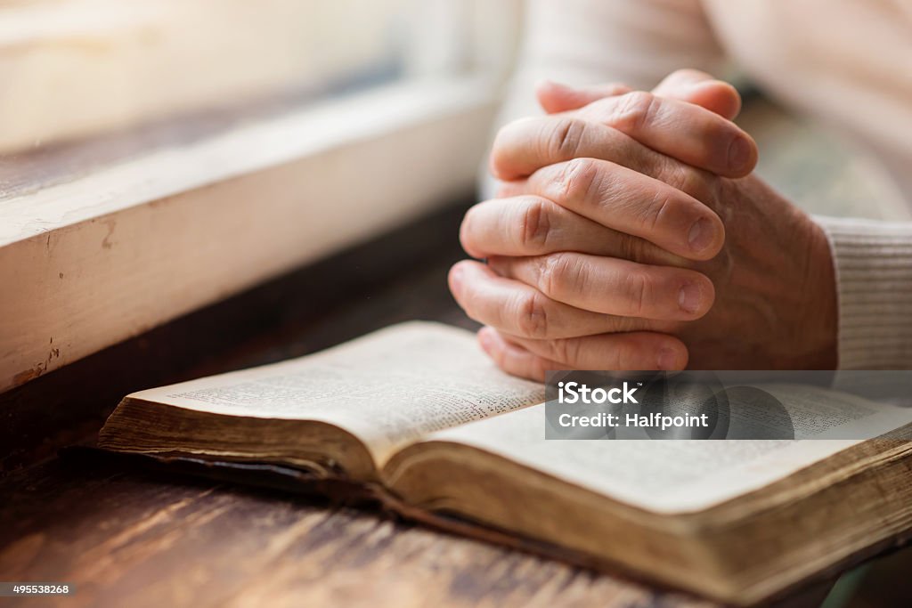 Woman with bible Unrecognizable woman holding a bible in her hands and praying Praying Stock Photo