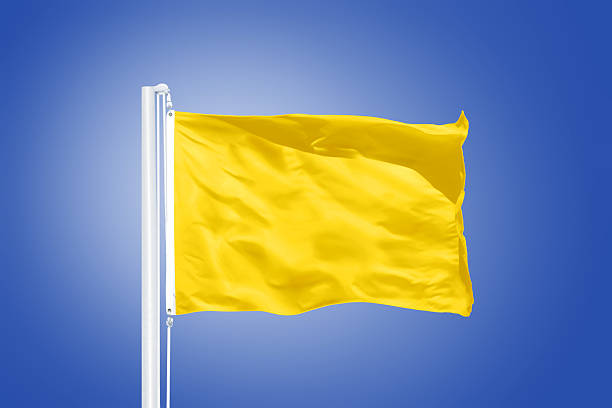 istock Yellow flag flying against clear blue sky 495538910
