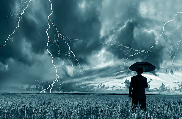 istock Man in black suit with a black umbrella in a storm 495540444