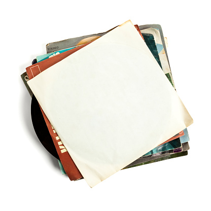 Stack of old vinyl records, high angle view, top one with blank sleeve, isolated on white background
