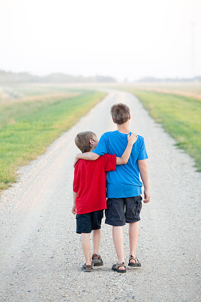 istock Two Boys Walking Down a Country Road 495540661