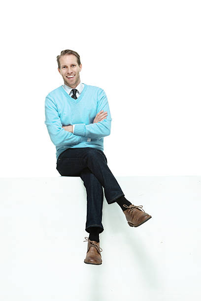 istock Front view of happy man sitting on ledge 495540675