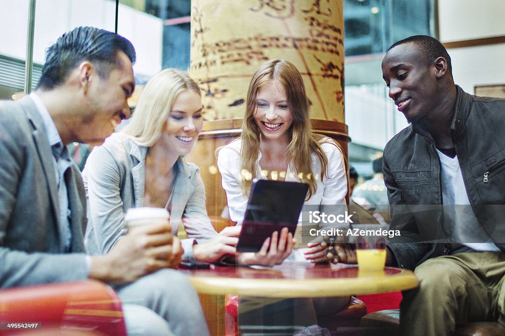 Friends in Hong Kong cafe Four friends watching digital tablet in Hong Kong cafe Adult Stock Photo