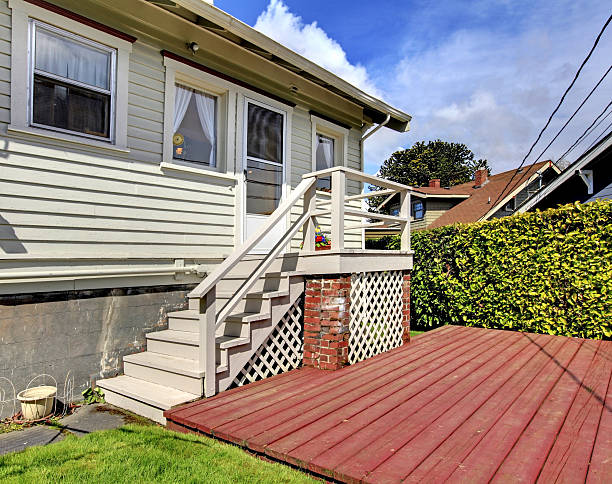 istock Small grey house with staircase to back yard deck. 495547245