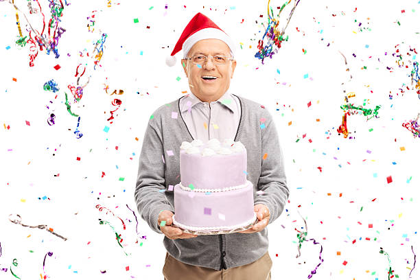 istock Senior man with Santa hat holding a cake 495557102