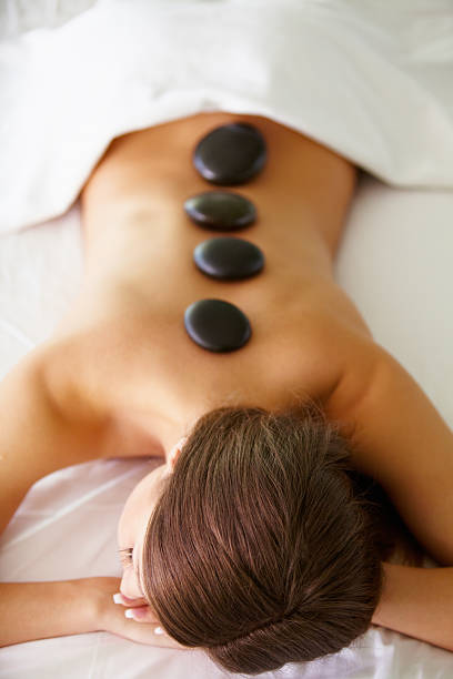 la joven tiene masaje hotstone en el spa - lastone therapy pampering spa treatment women fotografías e imágenes de stock