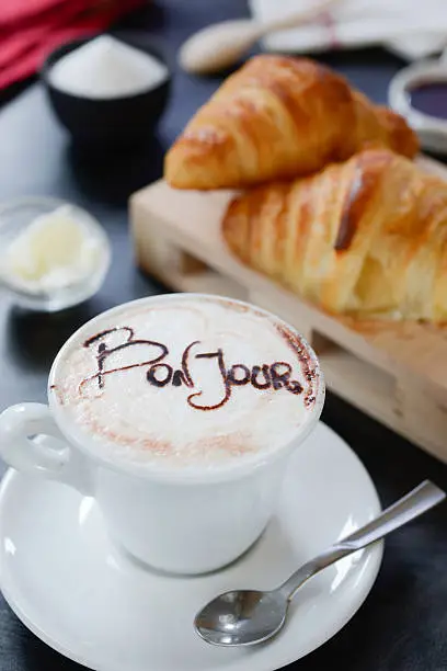 Decorated cappuccino and croissants